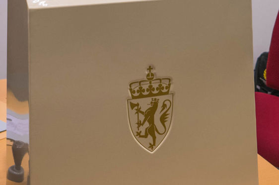 en hvit rektangulær boks med et gullemblem på