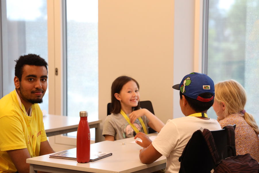 en gruppe mennesker som sitter ved et bord en gruppe mennesker som sitter ved et bord